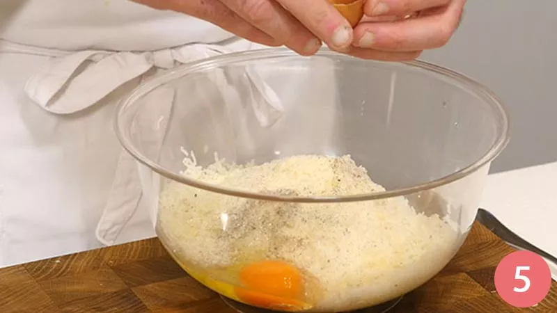 Trasferiamo il composto ottenuto in un capiente contenitore ed aggiungiamo un po' di pangrattato, il formaggio grana grattugiato, una spolverata di sale e pepe, un pizzico di noce moscata ed un uovo.